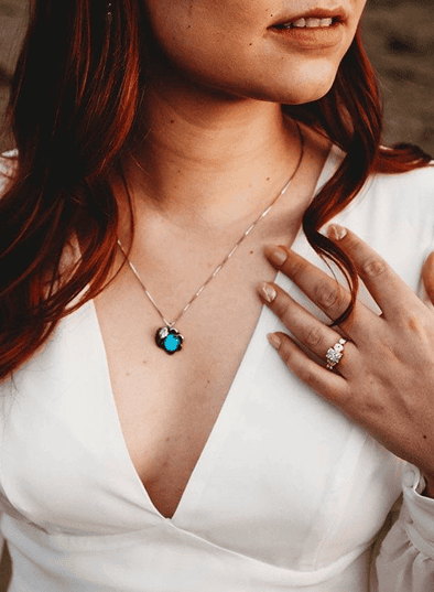 Woman wearing a dress and a turquoise necklace with a heart-shaped pendant